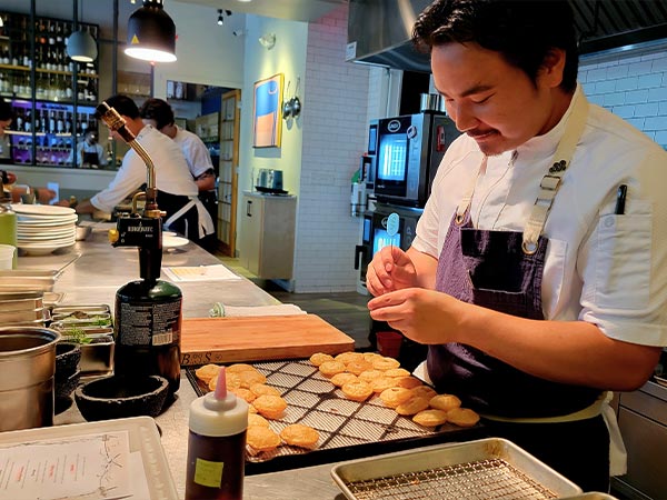 Chef preparing food at Mixtli's 90/90 dinner event