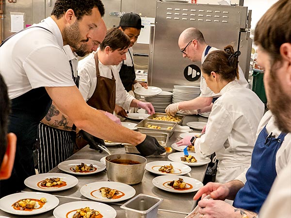 Chefs preparing a table of meals (Photo by Kate Morrison)