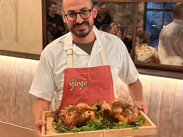 Chef with platter of chicken at Cafe Yaya
