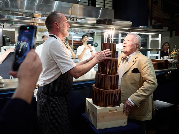 Chef Kyle Connaughton presenting Jacques Pepin with a birthday cake